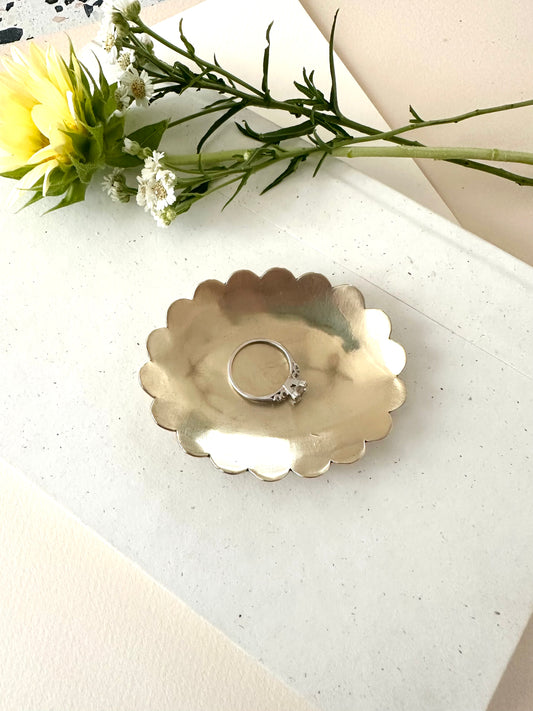 Sarah Cecelia Brass Ring dish with scallop edge and a diamond ring on a neutral background with florals