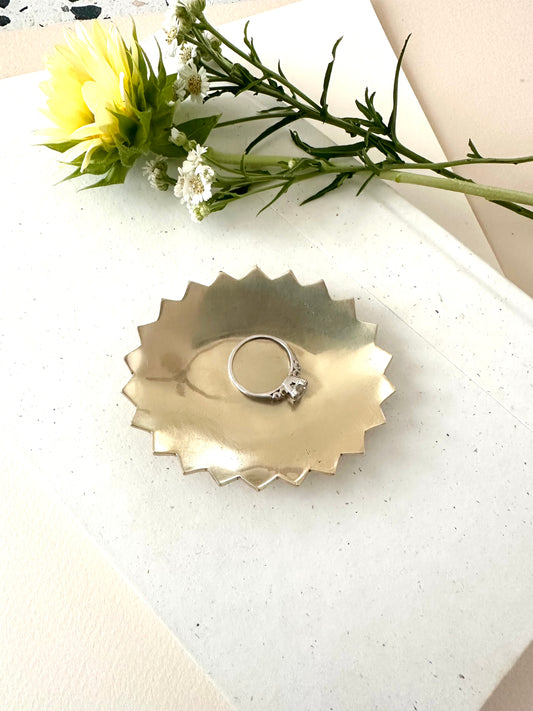 Sarah Cecelia Brass Pointe Ring dish with diamond ring on cream background with sunflower and greenery