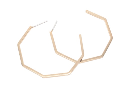 A pair geometric gold hoop earrings on a white background