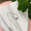 Sterling Silver Gemma Necklace displayed on a piece of marble with greenery