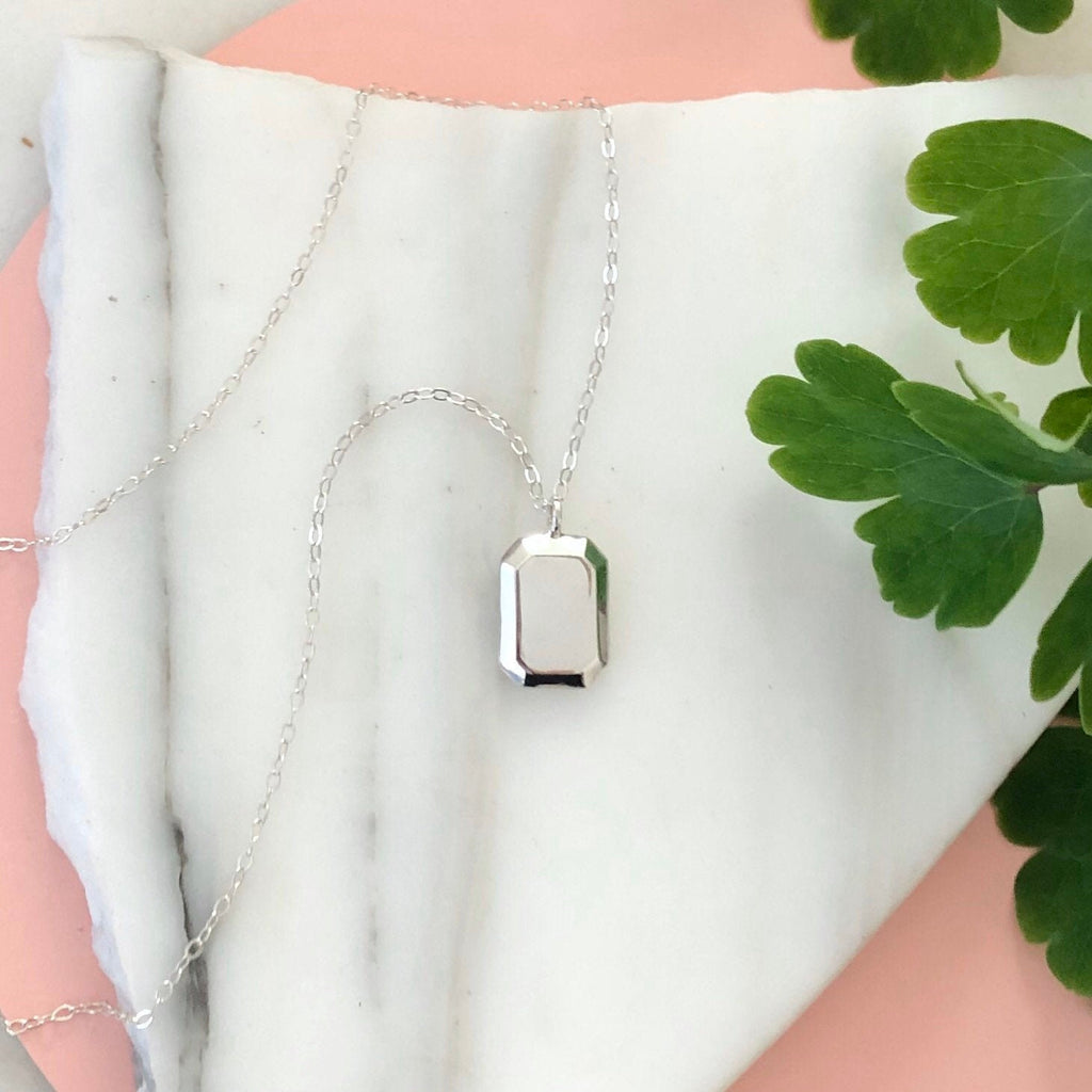 Sterling Silver Gemma Necklace displayed on a piece of marble with greenery